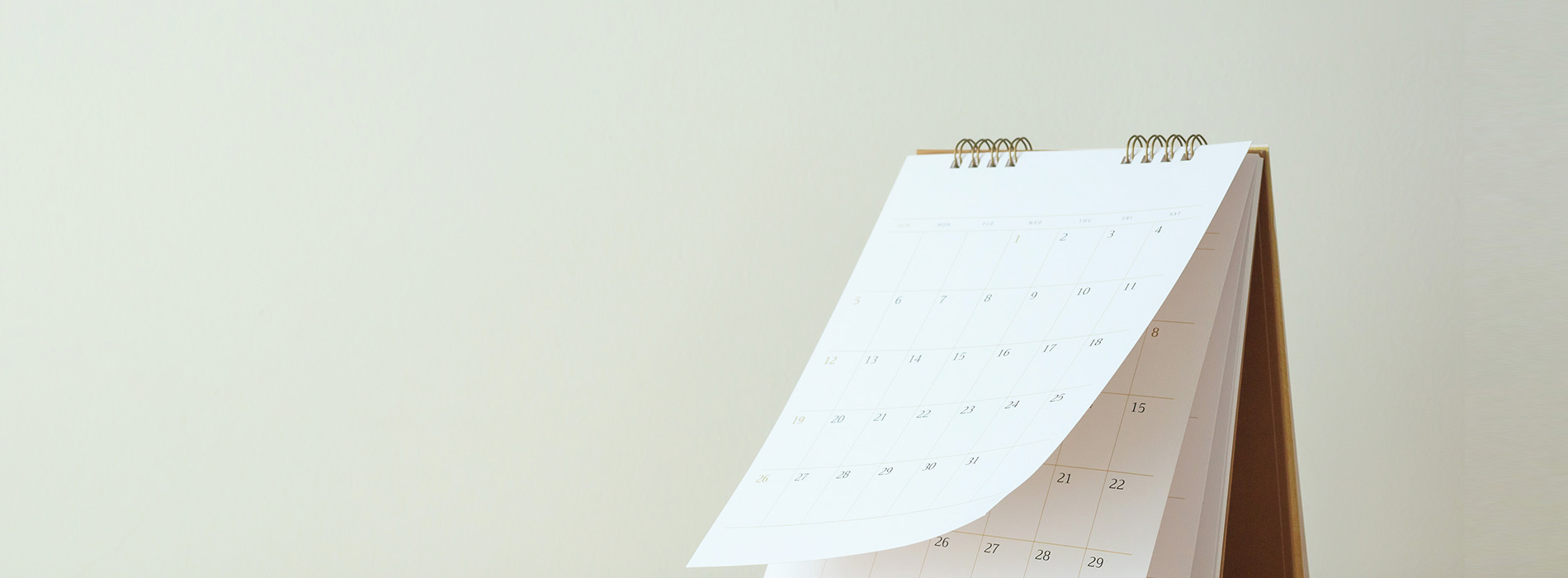 The image displays a calendar with a blank white background, placed on a flat surface, captured from an angle where part of the calendar is obscured by the edge of the frame.